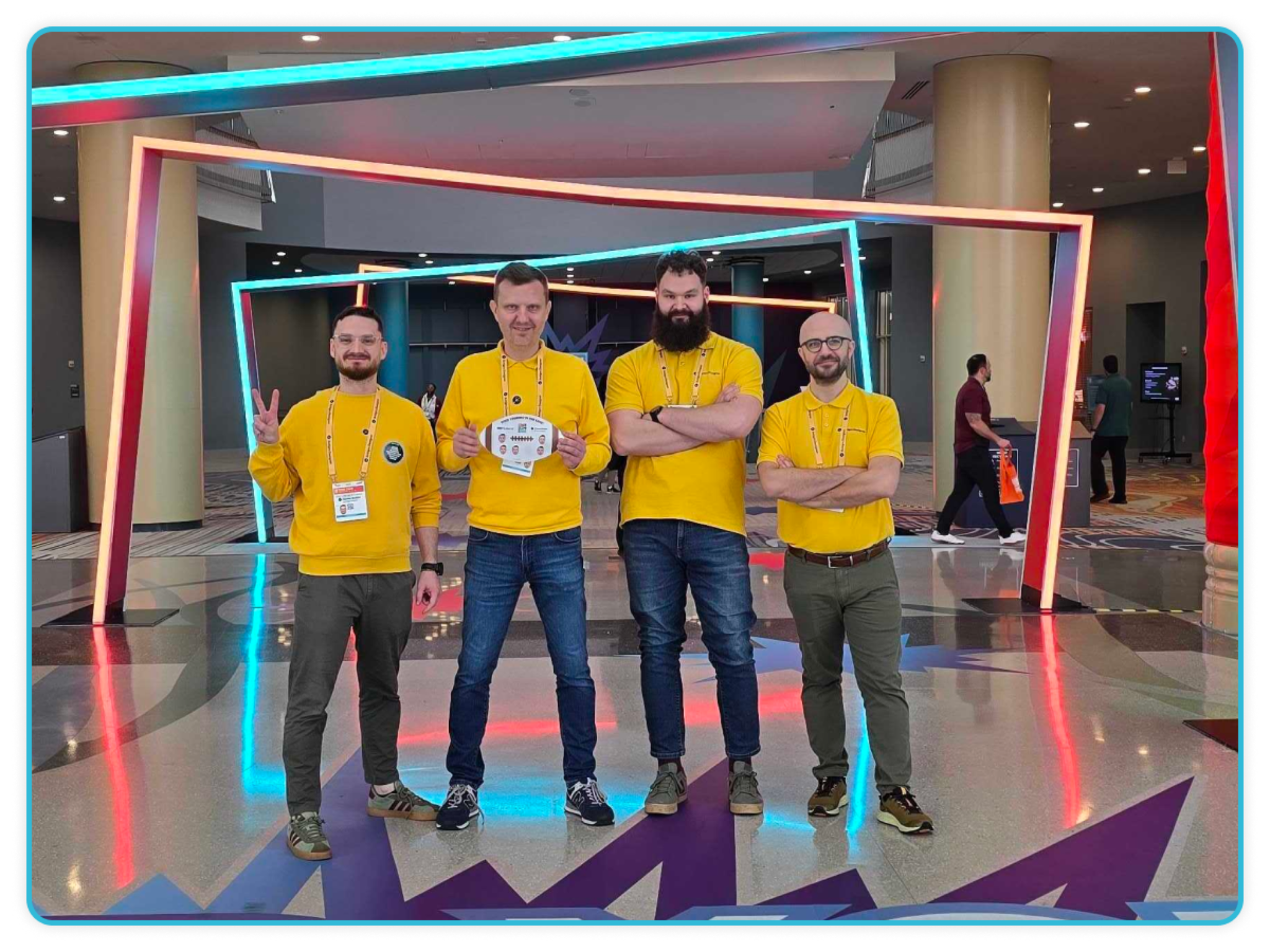 Four Sticker Builder team members in yellow shirts standing at ISA Sign Expo 2026 entrance with neon frames